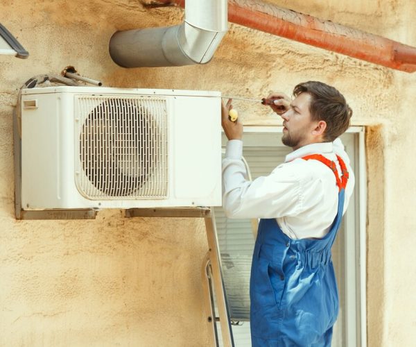Operaio effettua lavori di manutenzione di un impianto di condizionamento