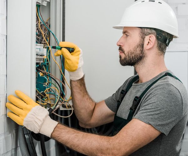 Elettricista effettua lavori di manutenzione di un impianto elettrico